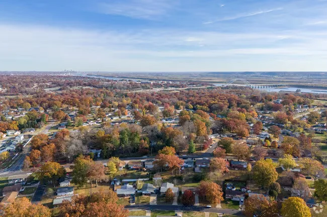 Aerial view of tree-lined Oakville neighborhoods in autumn with the Mississippi River beyond